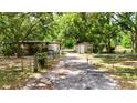 Gated driveway leading to home and detached garage at 26627 Brahma Dr, Wesley Chapel, FL 33544