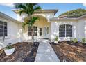 Inviting front entrance showcasing a well-maintained walkway, lush landscaping, and an arched doorway at 11019 Pine Lilly Pl, Lakewood Ranch, FL 34202