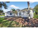 Elegant one-story home with manicured landscaping, featuring a front lawn and mature trees at 11019 Pine Lilly Pl, Lakewood Ranch, FL 34202