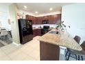 Modern kitchen with granite countertops, dark cabinets, stainless steel appliances and breakfast bar seating at 11124 Leland Groves Dr, Riverview, FL 33579