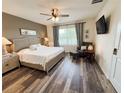 The main bedroom has a ceiling fan, hardwood floors, and a gray upholstered headboard at 11124 Leland Groves Dr, Riverview, FL 33579