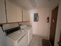 Laundry room featuring a washer, dryer, utility sink, overhead cabinets, and a tiled floor at 13382 Drummond Ave, Port Charlotte, FL 33953