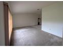 Spacious living room with neutral walls, carpet flooring and large windows providing natural light at 13382 Drummond Ave, Port Charlotte, FL 33953