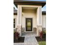 Inviting front entry with stone accents, brick pathway, and a modern glass paneled front door at 5079 Fairlane Dr, North Port, FL 34288