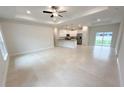 Bright, open-concept living room flows into the kitchen with recessed lighting and neutral tile flooring at 5079 Fairlane Dr, North Port, FL 34288