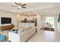 Bright open-concept living area with a modern kitchen, sleek furniture, and tile flooring at 5079 Fairlane Dr, North Port, FL 34288