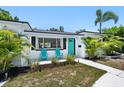 Front exterior of a home showcasing a turquoise door, fresh paint, and well-maintained landscaping at 707 63Rd S Ave, St Petersburg, FL 33705