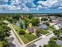 Overhead shot showcasing the property's idyllic setting amidst lush landscaping and a picturesque lake with a fountain at 7728 Balharbour Dr, New Port Richey, FL 34653