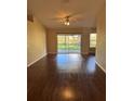 Bright living room featuring sleek wood floors, ceiling fan and sliding glass doors to the backyard at 837 Greenbelt Cir, Brandon, FL 33510