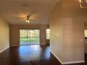 Bright living room featuring sleek wood floors, ceiling fan and sliding glass doors to the backyard at 837 Greenbelt Cir, Brandon, FL 33510