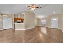 Open-concept living room with wood-look flooring and an abundance of natural light from the front door and kitchen at 837 Greenbelt Cir, Brandon, FL 33510