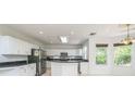 Bright kitchen with white cabinets, stainless steel appliances, and black countertops at 7716 Nottinghill Sky Dr, Apollo Beach, FL 33572