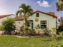 Cozy single-story home with tidy front yard featuring mature landscaping and unique decorative accents at 1244 E Corktree Cir, Port Charlotte, FL 33952