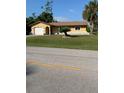 A charming single story home with a well-manicured front lawn and mature landscaping at 1409 Yorkshire St, Port Charlotte, FL 33952