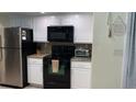 Galley kitchen with granite countertops, stainless steel appliances, and white cabinets at 1409 Yorkshire St, Port Charlotte, FL 33952