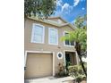 Attractive two-story home with a beige exterior and a nicely contrasting white trim, including a single-car garage at 4605 Ashburn Square Dr, Tampa, FL 33610