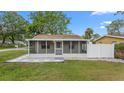 Charming home featuring a screened front porch, grey stone landscaping and ample sunlight at 7635 Pier Rd, Port Richey, FL 34668