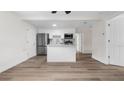 Bright open-concept kitchen featuring white cabinets, stainless steel appliances and an island at 7635 Pier Rd, Port Richey, FL 34668