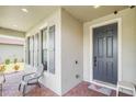 Inviting front porch with brick flooring, stylish shutters, and a cozy chair, enhancing curb appeal at 2647 Running Oak Ct, North Port, FL 34289