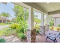 Charming front porch with brick accents and stone pillars, showcasing lush landscaping and neighborhood views at 2647 Running Oak Ct, North Port, FL 34289