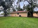 Back exterior view featuring green lawn, and mature trees at 131 49Th E Ct, Palmetto, FL 34221