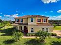 Beautiful two-story home with a tile roof, red shutters, and vibrant landscaping at 7315 Bianco Duck Ct, Sarasota, FL 34240