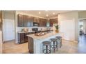Modern kitchen featuring a large island with seating, granite countertops, dark wood cabinetry, and stainless steel appliances at 12518 Maginn Ct, Weeki Wachee, FL 34614