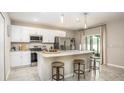 Modern kitchen with stainless steel appliances, granite countertops, and a center island with bar stool seating at 11427 Pickford St, Spring Hill, FL 34609