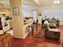 Open living room and kitchen with hardwood floors and breakfast bar at 4147 Kingsfield Dr, Parrish, FL 34219