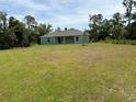 View of the back of the house and large backyard at 4619 Chamrade Rd, North Port, FL 34288