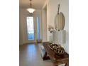 Bright entryway with tile floors, console table, and mirror at 3101 Hollow Hickory Pl, Wesley Chapel, FL 33543