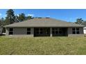 Back exterior of home showing a covered patio and a spacious lawn at 12283 Ipswich Sparrow Rd, Weeki Wachee, FL 34614