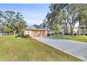 Single-story house with a driveway and mature trees at 9111 Blaine Rd, Spring Hill, FL 34608