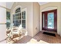 Front porch with brick flooring and two chairs at 19617 Sunset Bay Dr, Land O Lakes, FL 34638