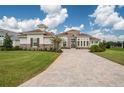Luxury home with stone accents, tile roof, and paver driveway at 13744 Carryback Dr, Dade City, FL 33525