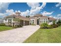 Luxury home with stone accents, tile roof, and paver driveway at 13744 Carryback Dr, Dade City, FL 33525