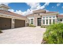 Luxury home with three-car garage and paver driveway at 13744 Carryback Dr, Dade City, FL 33525