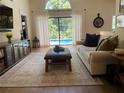 Relaxing living room with pool view, comfortable seating, and large windows at 615 Deer N Run, Palm Harbor, FL 34684