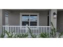 A cozy front porch area with white railings and lush green plants at 13221 Gulf Bay Ln, Spring Hill, FL 34609