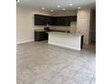 Spacious open-plan kitchen featuring dark cabinetry, stainless steel appliances, and granite countertops at 7724 Swiss Ave, North Port, FL 34291