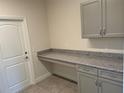 Functional laundry room with granite countertop and gray cabinets offering ample storage space at 1449 Marjorie Ln, North Port, FL 34286