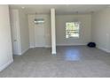 Bright living room with neutral paint, tile flooring, and large window providing natural light at 1449 Marjorie Ln, North Port, FL 34286