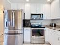 Modern kitchen features stainless steel appliances, granite countertops, and white cabinetry for a clean, updated look at 2457 Tamworth Ter, Punta Gorda, FL 33983
