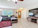 Comfortable living room featuring neutral paint, tile floors, a ceiling fan, and lots of natural light at 2457 Tamworth Ter, Punta Gorda, FL 33983