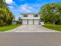 Two-story home with three-car garage and light-blue trim is set back from the street at 1731 Clearwater Harbor Dr, Largo, FL 33770