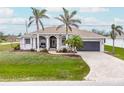 Charming home with palm trees, lovely landscaping, and a covered front porch at 8305 Welsford Rd, Port Charlotte, FL 33981