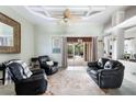 Inviting living room featuring tile floors, a unique fan, and comfortable black leather furnishings at 8305 Welsford Rd, Port Charlotte, FL 33981