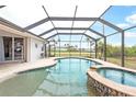 Inviting screened-in pool with attached spa and an expansive outdoor view at 8305 Welsford Rd, Port Charlotte, FL 33981