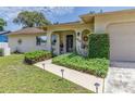 Charming front entrance with manicured bushes and a decorative front door at 5078 Kenmore St, Spring Hill, FL 34608