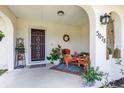 Inviting front porch with decorative wreath, outdoor seating, and colorful accent rug at 5078 Kenmore St, Spring Hill, FL 34608